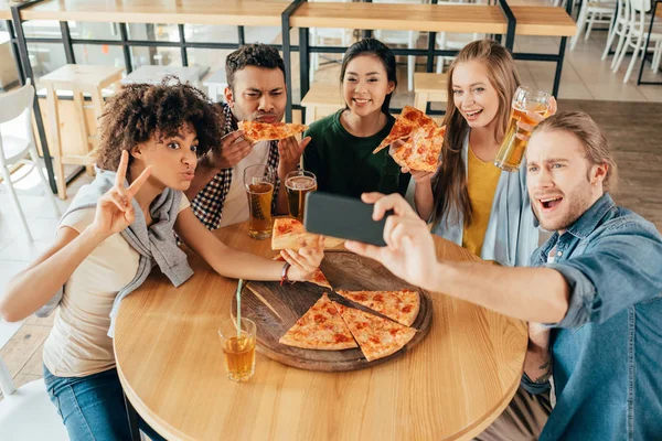 Amigos tomando selfie com pizza no café — Fotografia de Stock