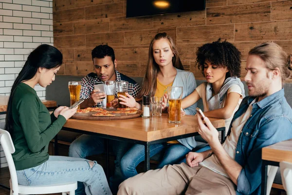 Amici con dispositivi digitali al caffè — Foto stock