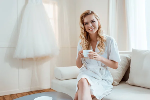 Frau trinkt Kaffee auf Sofa — Stockfoto