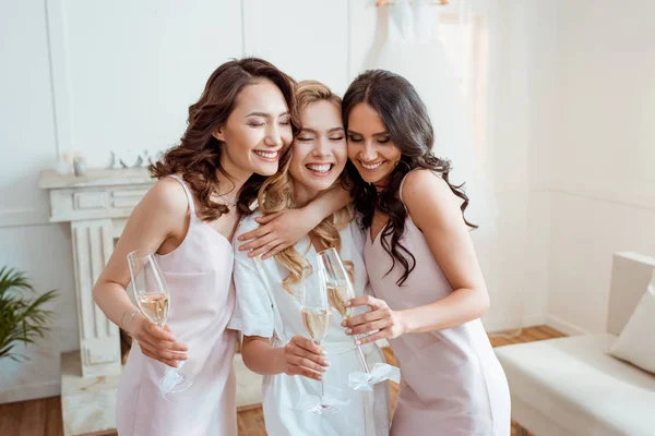 Bride with bridesmaids embracing and toasting — Stock Photo