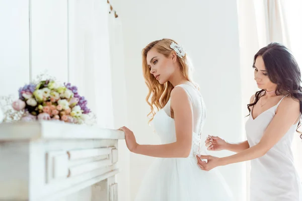 Dama de honor preparando novia para la ceremonia - foto de stock