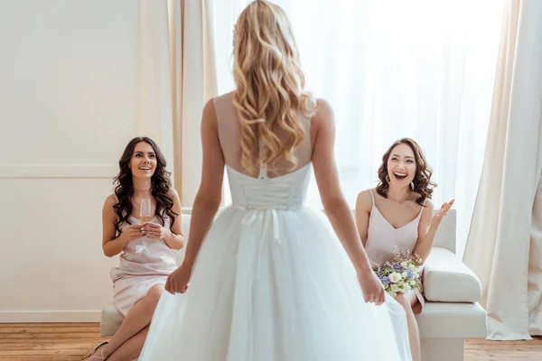 Excited bridesmaids looking at bride — Stock Photo