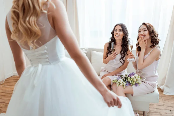 Aufgeregte Brautjungfern schauen Braut an — Stockfoto
