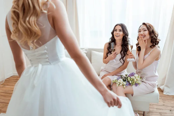 Demoiselles d'honneur excitées regardant mariée — Photo de stock