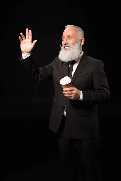 Businessman with coffee waving hand — Stock Photo