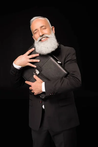 Businessman embracing briefcase — Stock Photo