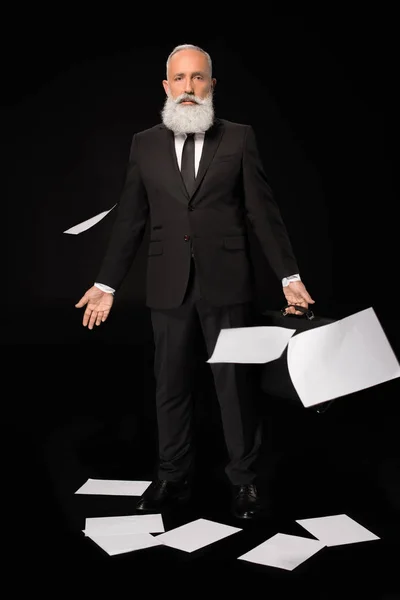 Hombre de negocios rodeado de papeles dispersos - foto de stock