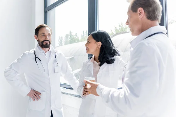 Doctors talking and drinking coffee — Stock Photo