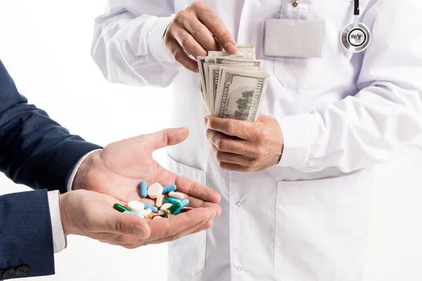 Businessman buying pills from doctor — Stock Photo