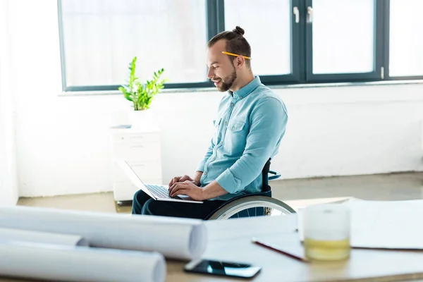 Businessman in wheelchair using laptop — Stock Photo