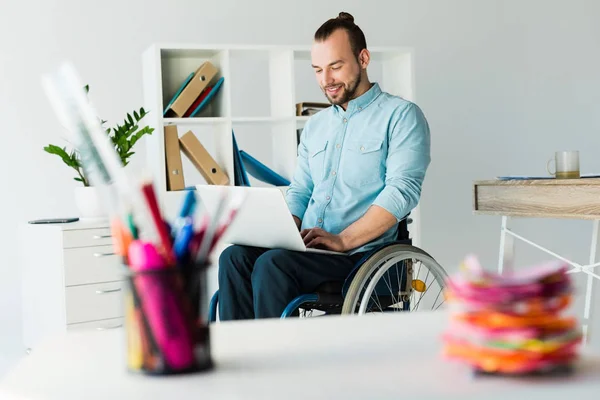Homem de negócios em cadeira de rodas usando laptop — Fotografia de Stock