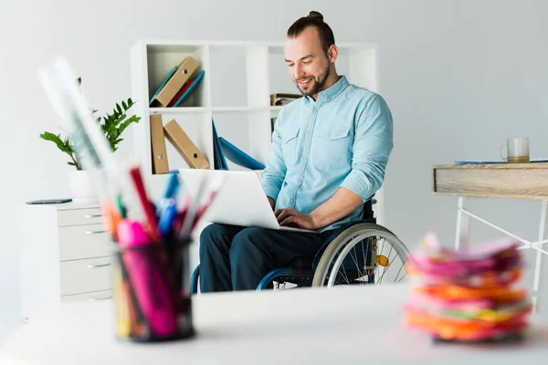 Homme d'affaires en fauteuil roulant en utilisant un ordinateur portable — Photo de stock