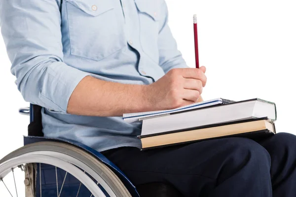 Человек в инвалидной коляске с книгами — стоковое фото