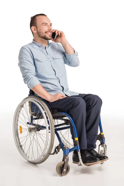 Man in wheelchair talking on smartphone — Stock Photo
