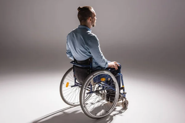 Человек на инвалидной коляске бросает тень — стоковое фото