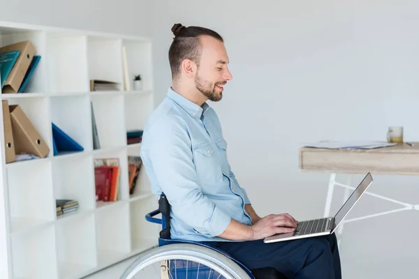 Uomo d'affari sulla sedia a rotelle che lavora con il computer portatile — Foto stock