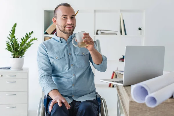Инвалид бизнесмен пьет кофе — стоковое фото