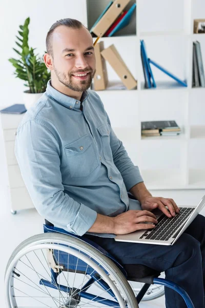 Бизнесмен в инвалидной коляске с помощью ноутбука — стоковое фото