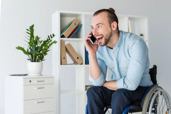 Man in wheelchair talking on smartphone — Stock Photo