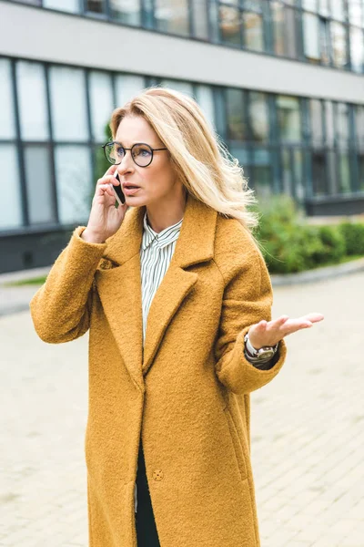 Verwirrte Frau spricht auf Smartphone — Stockfoto