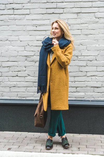 Mujer pensativa en abrigo amarillo - foto de stock