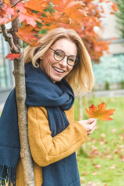 Frau mit Blatt im Herbstpark — Stockfoto