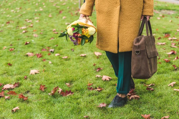 Frau mit Blumenstrauß und Tasche — Stockfoto
