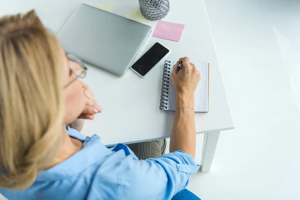 Businesswoman writing in diary — Stock Photo