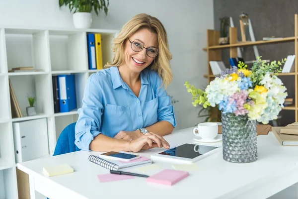 Empresaria que trabaja con dispositivos digitales - foto de stock