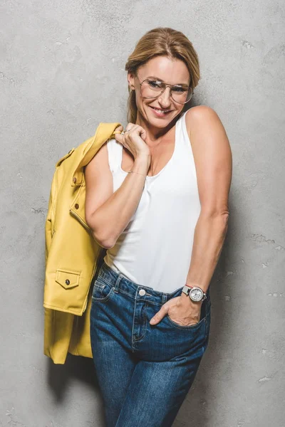 Lächelnde Frau mit gelber Lederjacke — Stockfoto