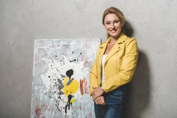 Blonde woman with painting — Stock Photo