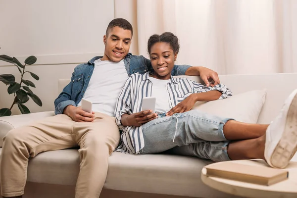 Couple sitting with smartphones — Stock Photo