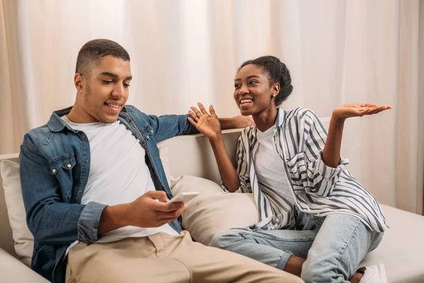 Couple sitting on couch and talking — Stock Photo