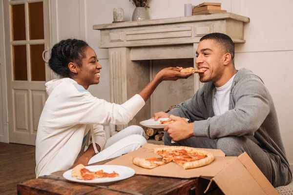 Mulher alimentando homem pizza — Fotografia de Stock