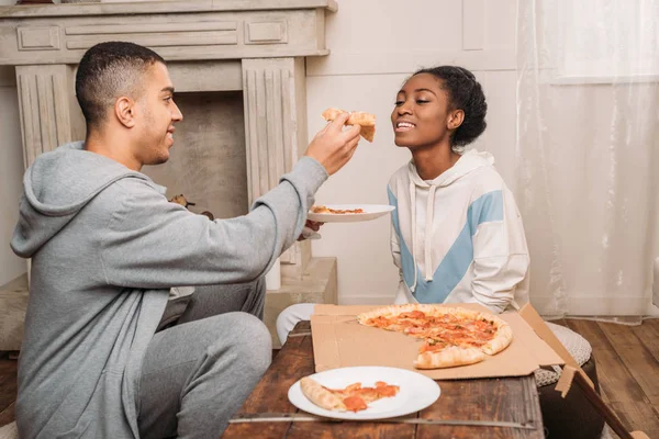 Man sharring pizza slice to girlfriend — Stock Photo