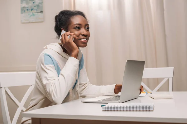 Femme avec ordinateur portable parlant au téléphone — Photo de stock