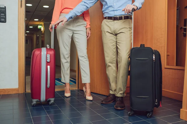 Cropped shot of mature couple with suitcases entering into hotel room — Stock Photo