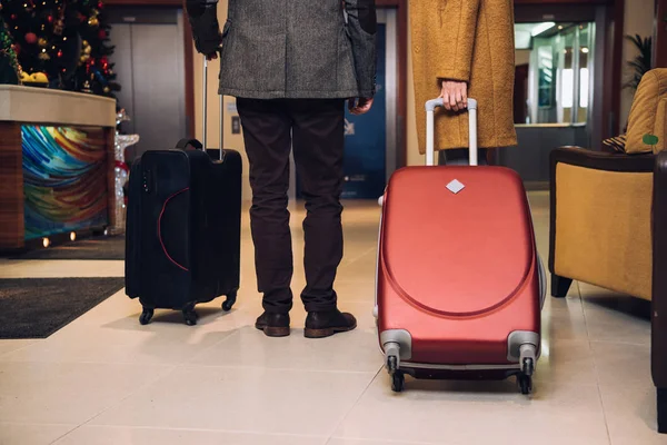 Cropped shot of couple with suitcases walking at hotel hallway — Stock Photo