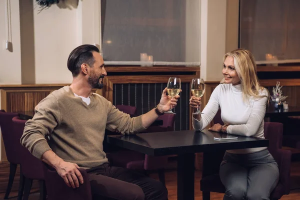 Belo feliz casal de meia idade bebendo vinho e sorrindo uns aos outros no restaurante do hotel — Fotografia de Stock