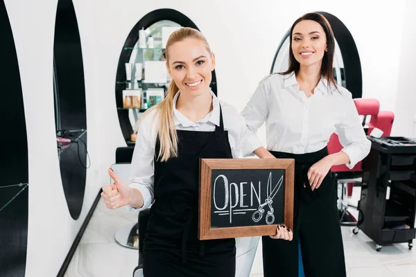 Парикмахер держит вывеску открытой и показывает большой палец вверх — Stock Photo