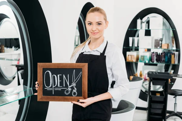 Привлекательный парикмахер держит табличку открытой — Stock Photo