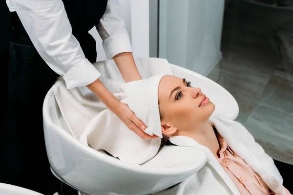 Обрізане зображення перукаря сушіння праного волосся клієнта з рушником — стокове фото