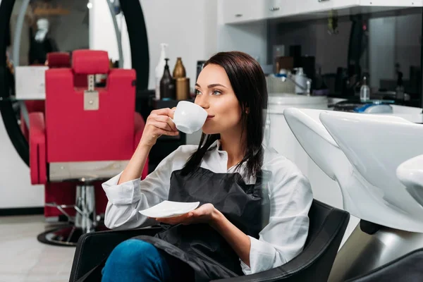 Hairdresser drinking coffee during lunch time — Stock Photo