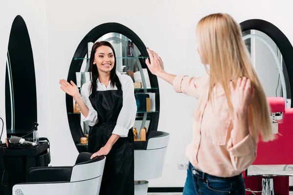 Kundin winkt Friseur im Salon zu — Stockfoto