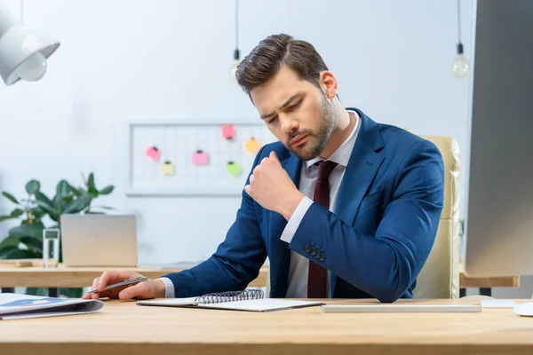 Uomo d'affari concentrato guardando le note nel quaderno — Foto stock