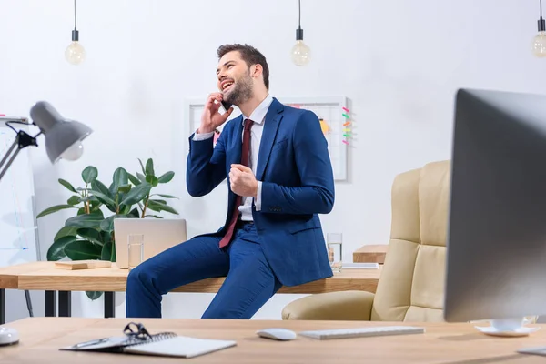 Glücklicher Geschäftsmann, der im Büro per Smartphone spricht und Ja-Geste zeigt — Stockfoto