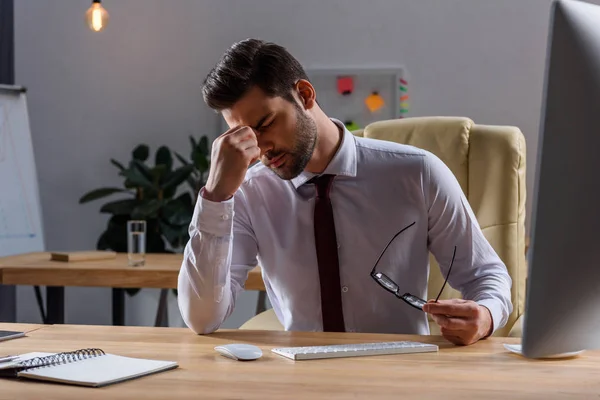 Kranker Geschäftsmann hat Kopfschmerzen, wenn er abends im Büro arbeitet — Stockfoto