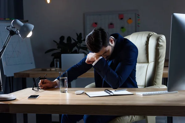 Kranker Geschäftsmann hat Kopfschmerzen, wenn er abends im Büro arbeitet — Stockfoto