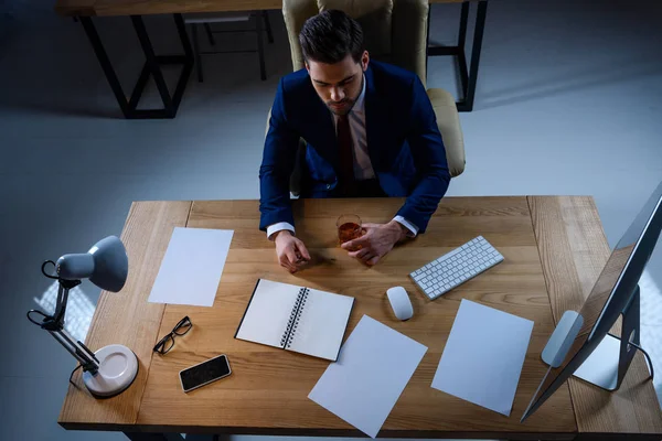 Vue aérienne de l'homme d'affaires assis avec un verre de whisky au bureau — Photo de stock