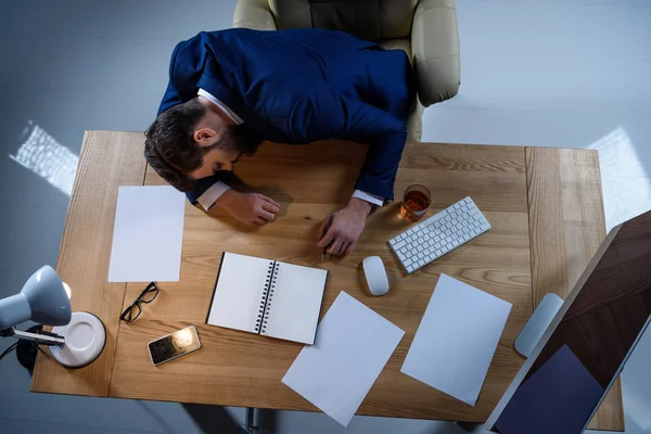 Vista aérea del hombre de negocios durmiendo en la mesa de trabajo - foto de stock